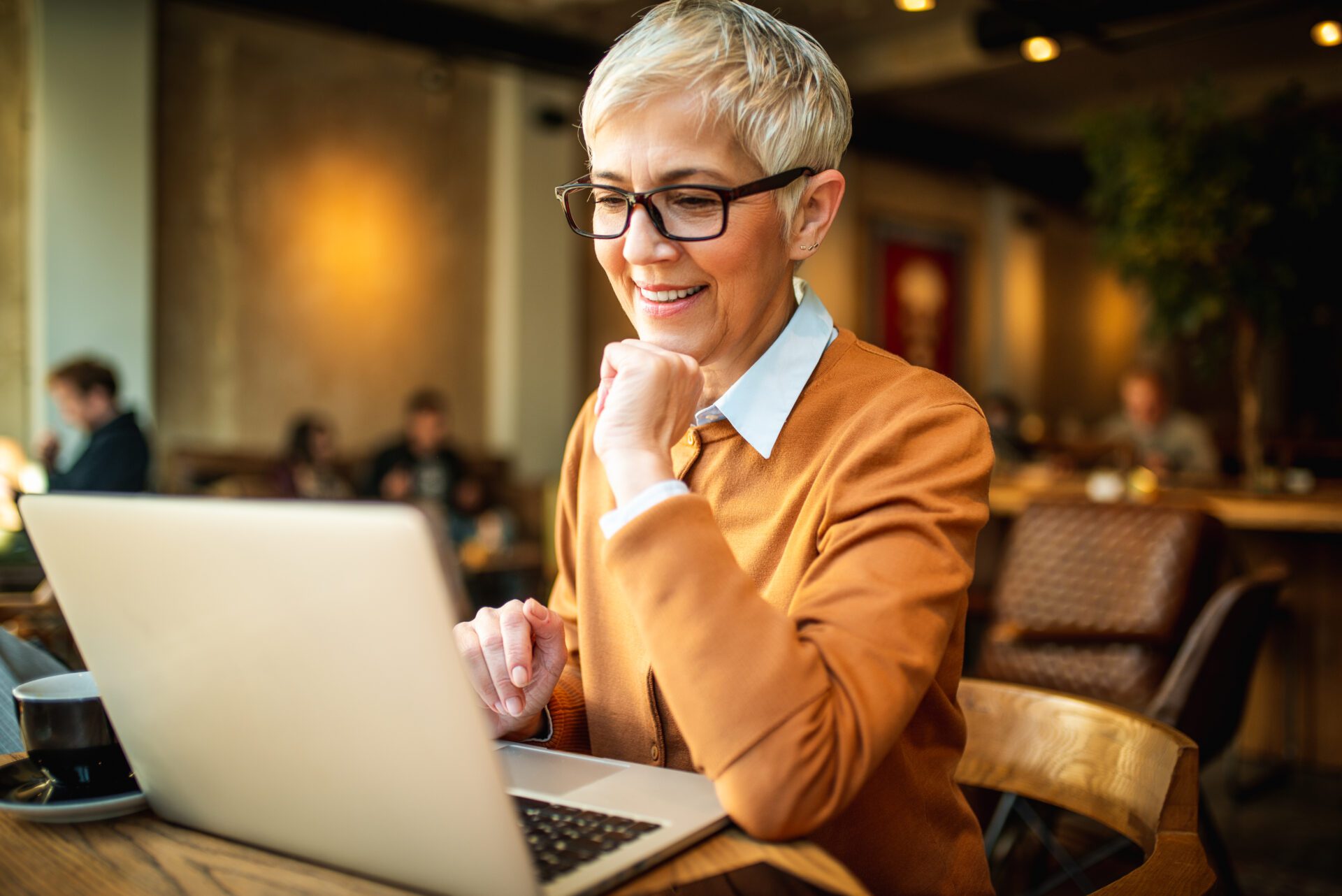 Smiling senior business woman using laptop. Rezept Janning Immobilien